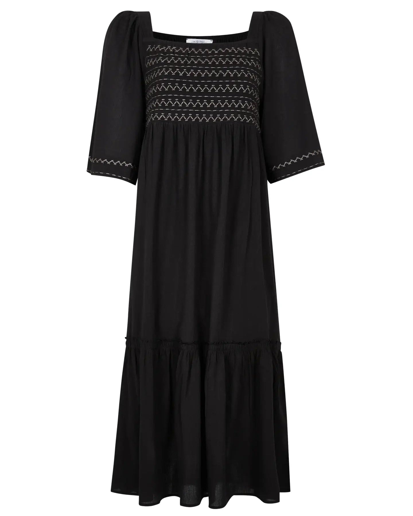 Black dress with embroidered details on a white background