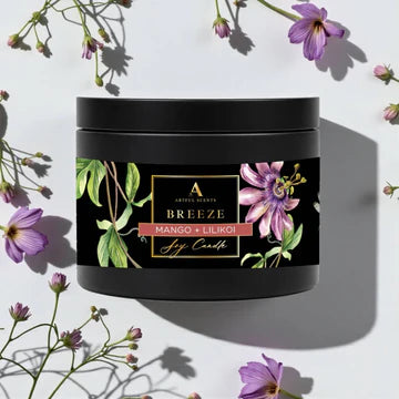 Black candle jar with floral design and 'Breeze' label on a light background with flowers.
