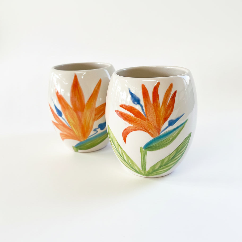 Two ceramic cups with floral designs on a white background