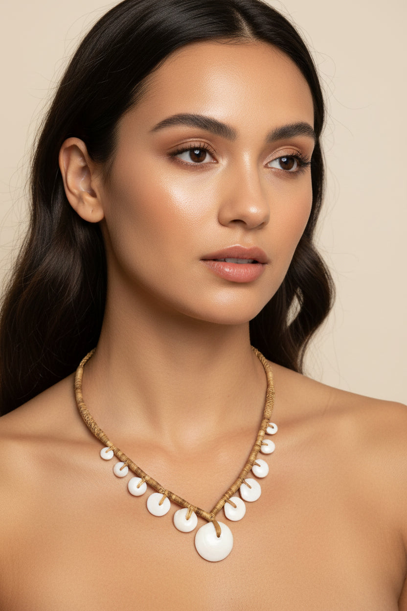 Necklace with white puka shells on a black background