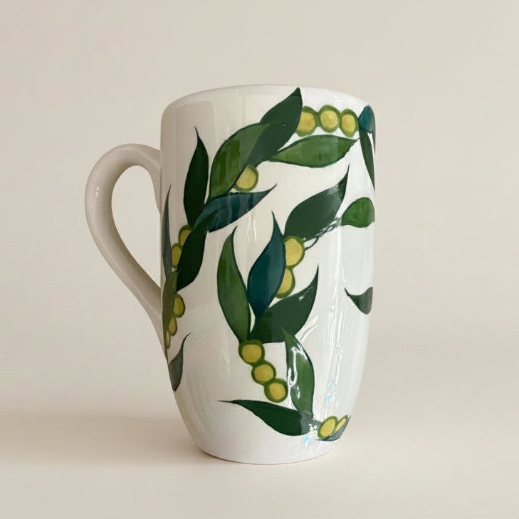 Mug with green leaf and berry design on a white background