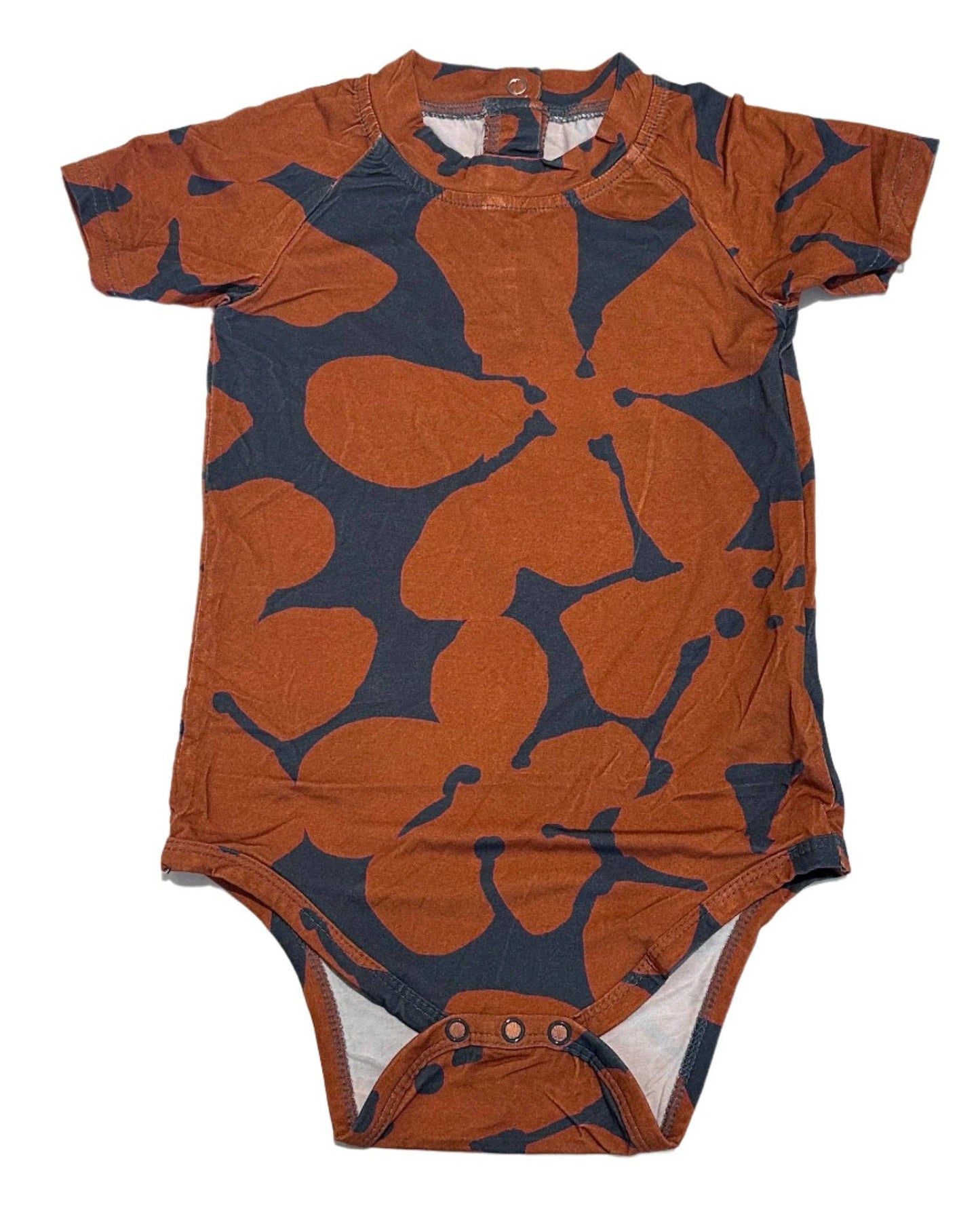 Baby bodysuit with orange and navy abstract pattern on a white background