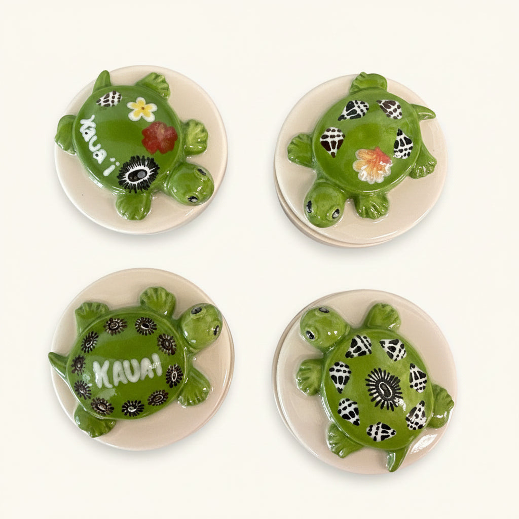 Four ceramic turtle plates with decorative patterns on a textured surface