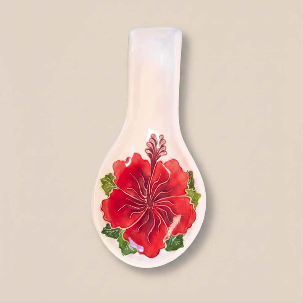 A ceramic spoon rest with a red hibiscus