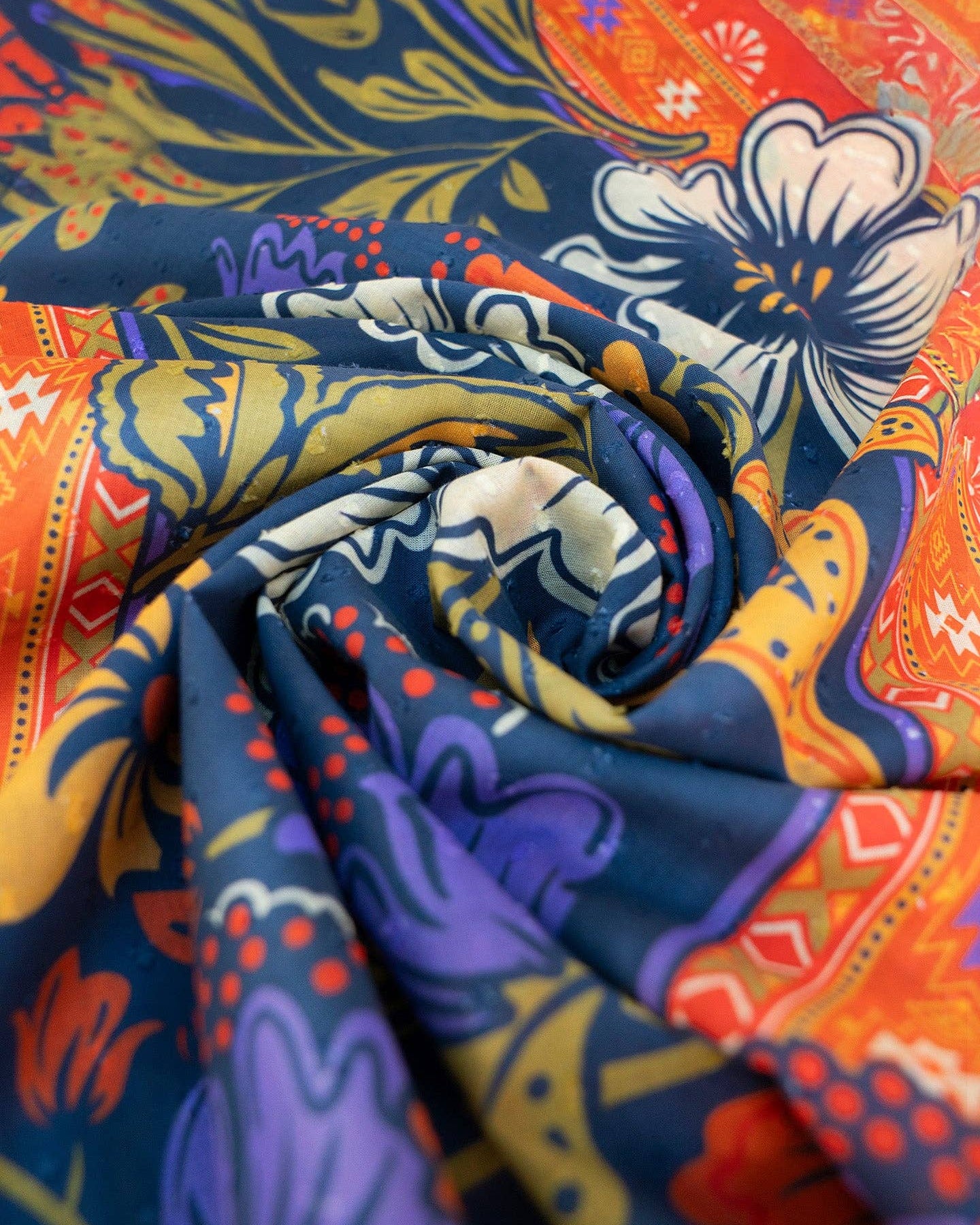 Colorful fabric with intricate patterns in blue, orange, yellow, and purple.