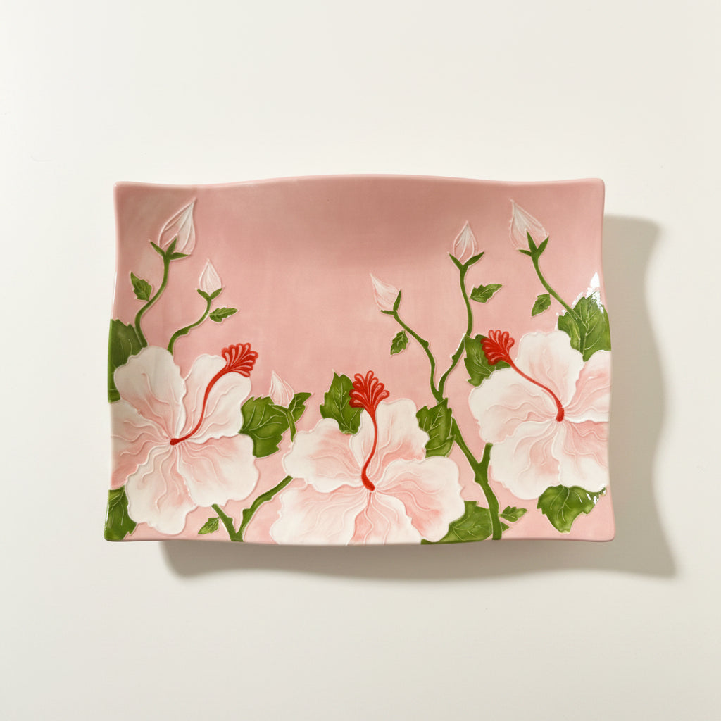 Floral-patterned fabric with pink flowers and green leaves on a light pink background