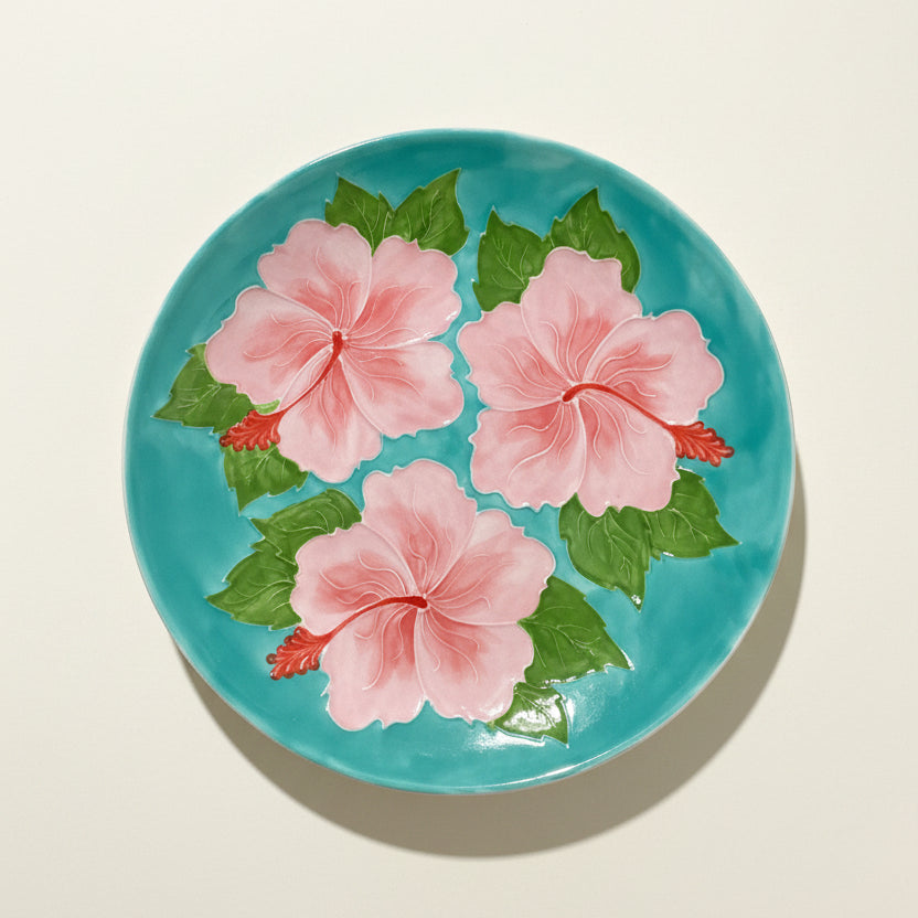 Decorative plate with pink floral design on a blue background