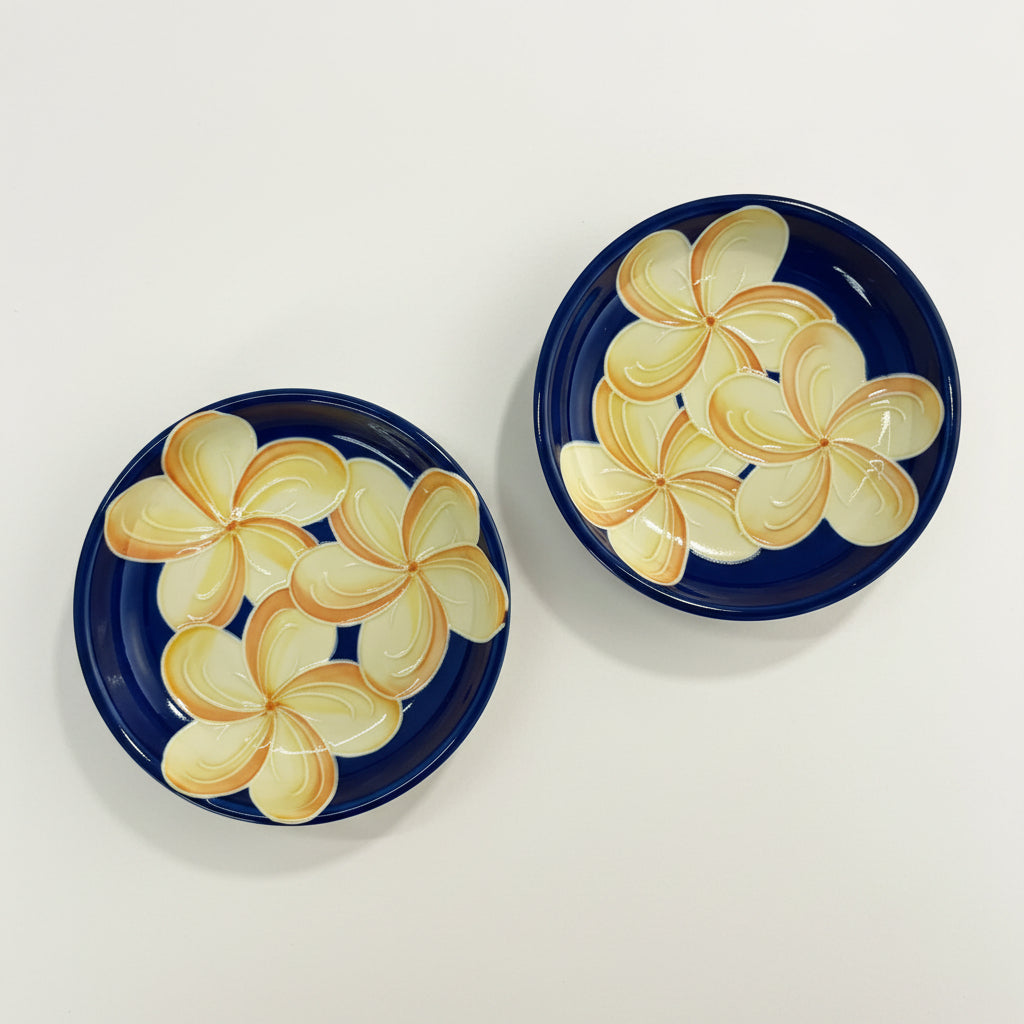 Two ceramic plates with floral designs on a textured surface