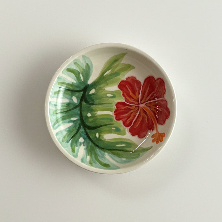 Ceramic plate with a red floral design on a gray background