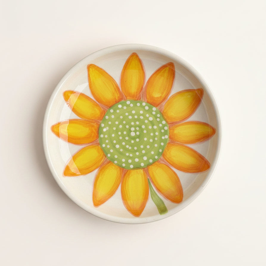 Decorative plate with a sunflower design on a dark surface