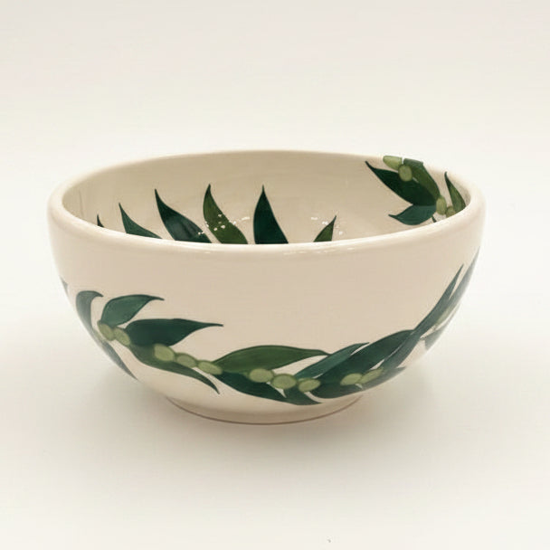 Ceramic bowl with green leaf pattern on a white background