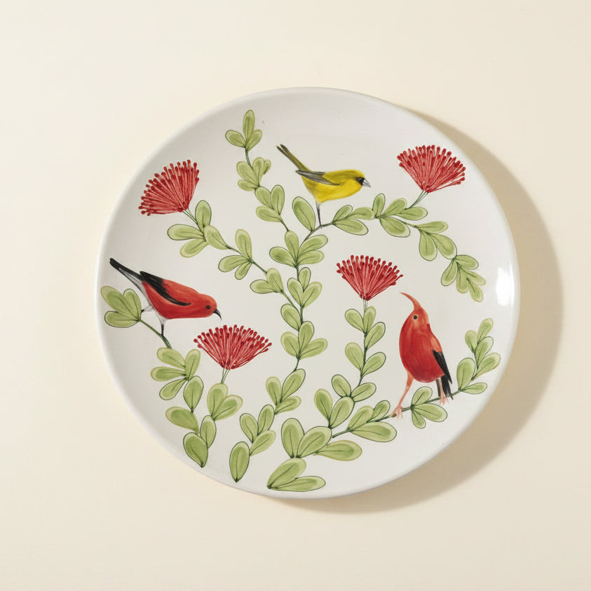 Round ceramic plate with bird and flower design on a white background