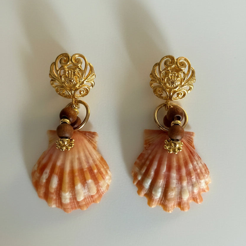 Pair of shell earrings with gold accents on a light background