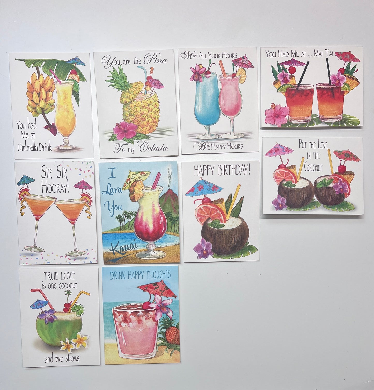 Collection of greeting cards with tropical-themed designs on a white surface.