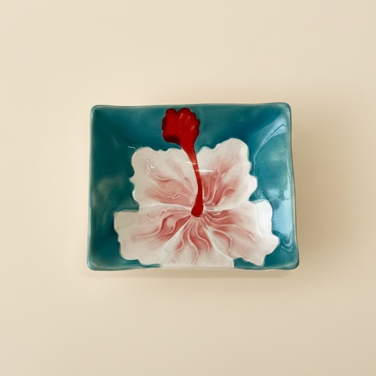 A set of hand-painted ceramic sauce dishes with a hibiscus flower design, in shades of blue and with pink, orange, and yellow flowers.