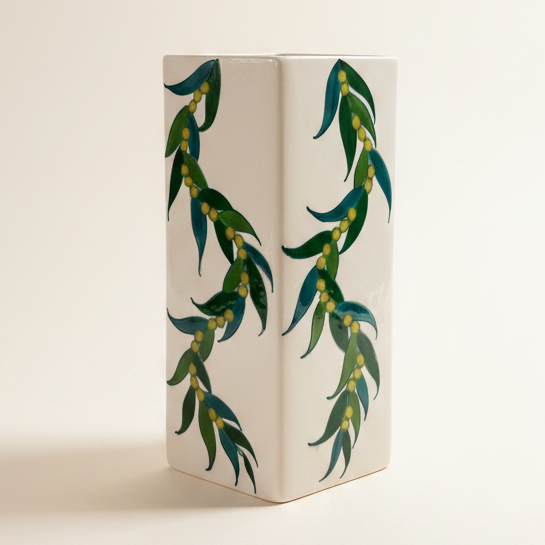 Decorative vase with green leaf pattern on a white background