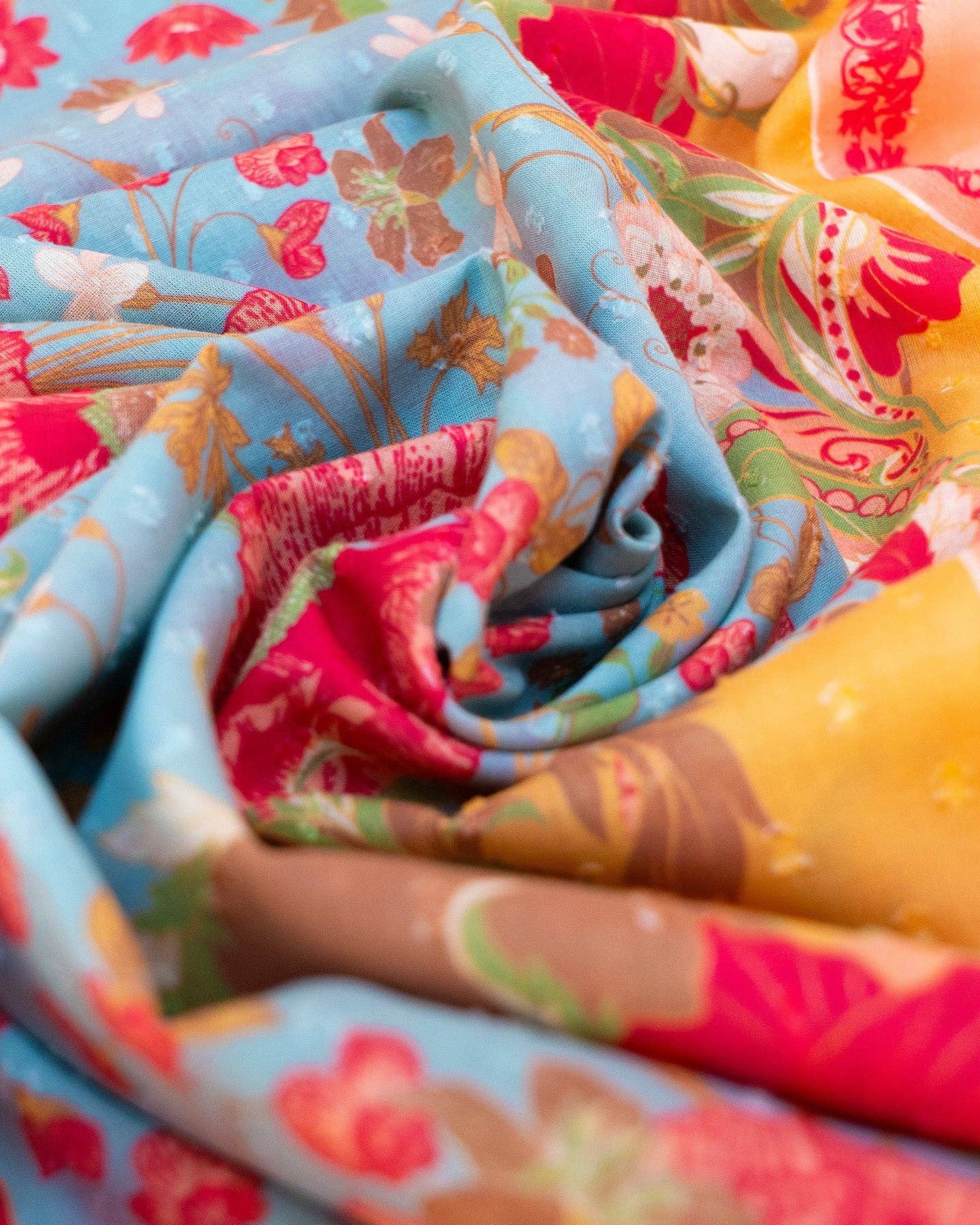 Close-up of colorful fabric with floral patterns in blue, red, and yellow.