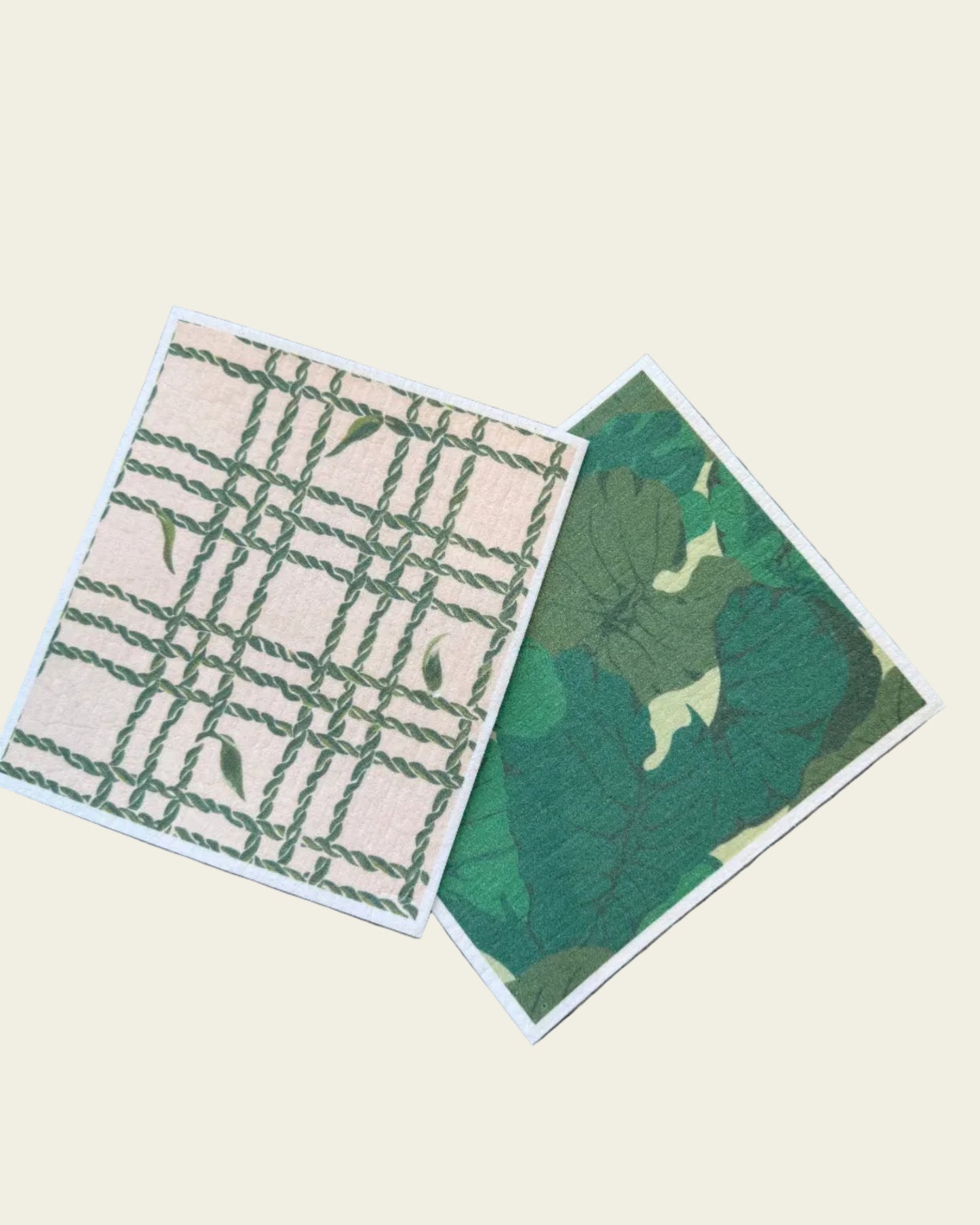Two green and beige patterned cards on a textured surface