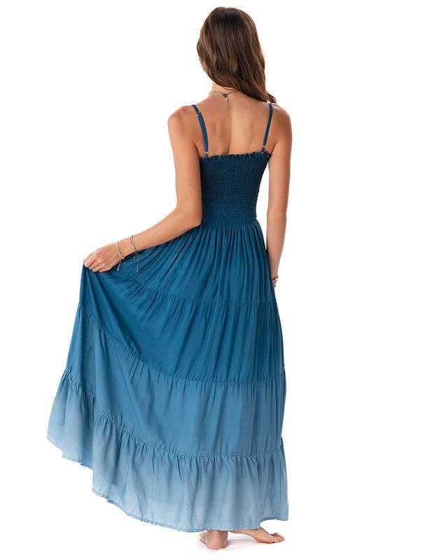 Woman wearing a blue tiered dress on a white background