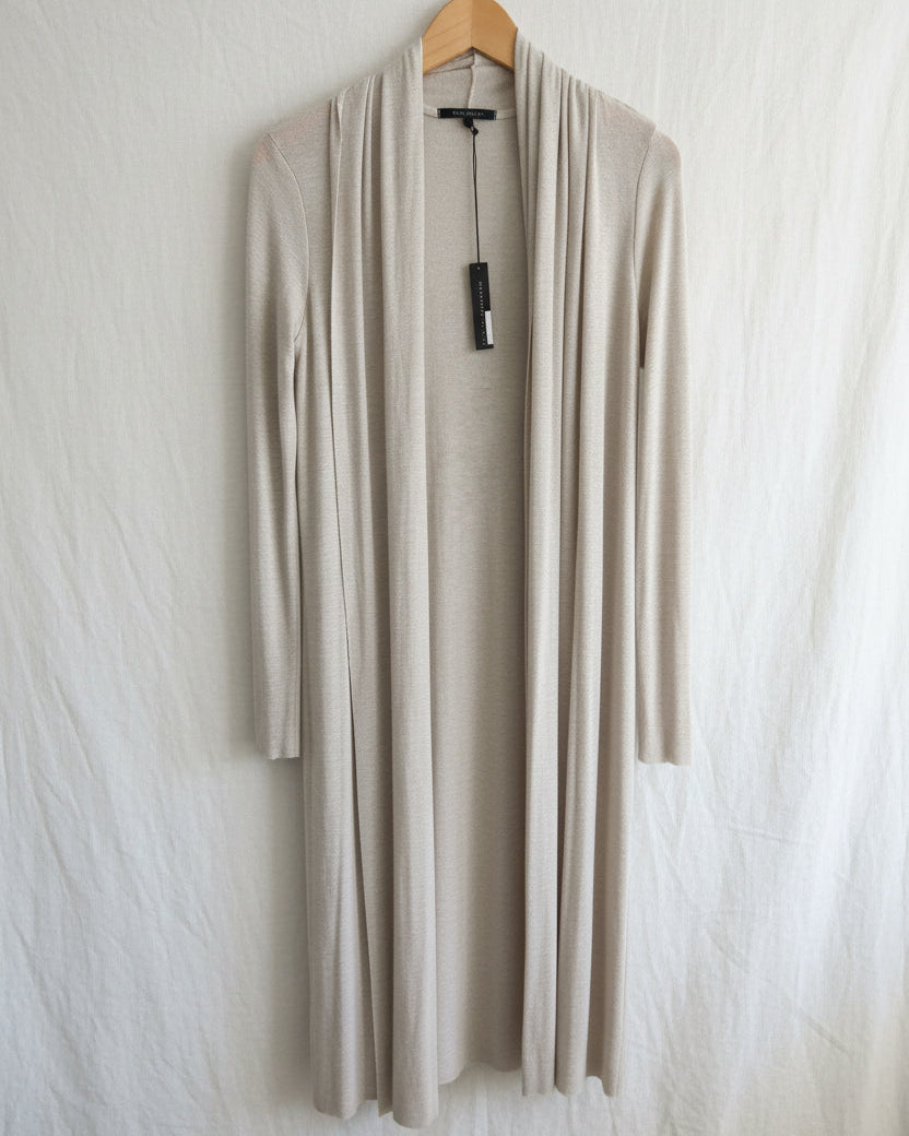 Beige cardigan on a hanger against a white background
