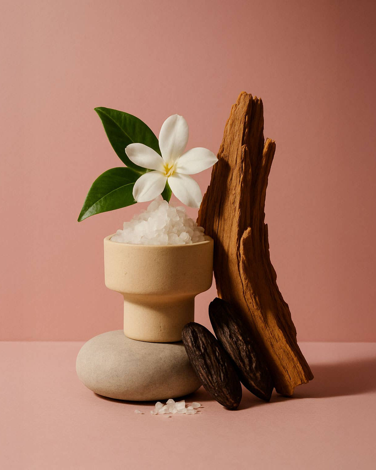Cylindrical container with white flowers and a piece of wood on a pink background