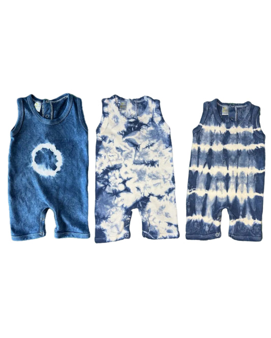 Three Baby Indigo Shibori Tie Dye Rompers in various stages of the tie-dye pattern, displayed flat.