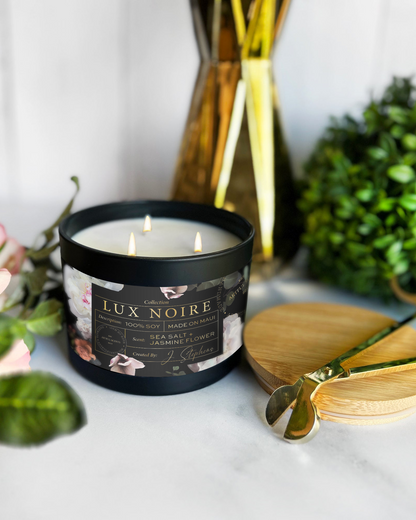 Lux Noire candle on a table with flowers and decorative items