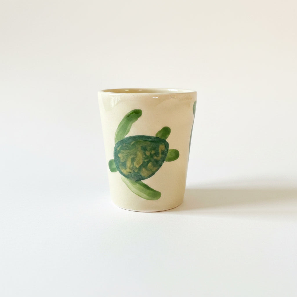 Ceramic soap dish with a green turtle design on a gray surface