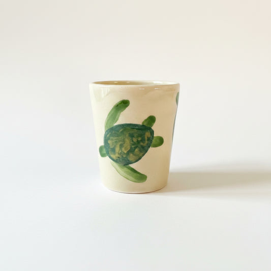 Ceramic soap dish with a green turtle design on a gray surface