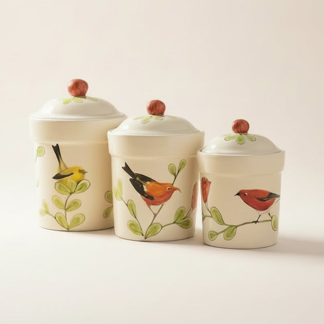 Three ceramic canisters with bird designs on a white background