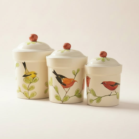 Three ceramic canisters with bird designs on a white background