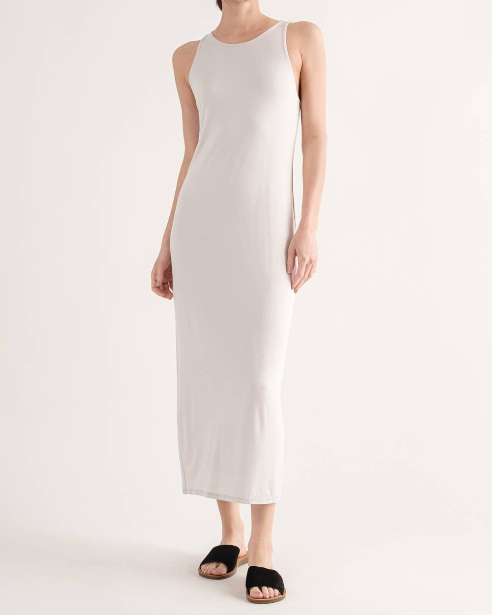 Woman wearing a white sleeveless dress on a plain background