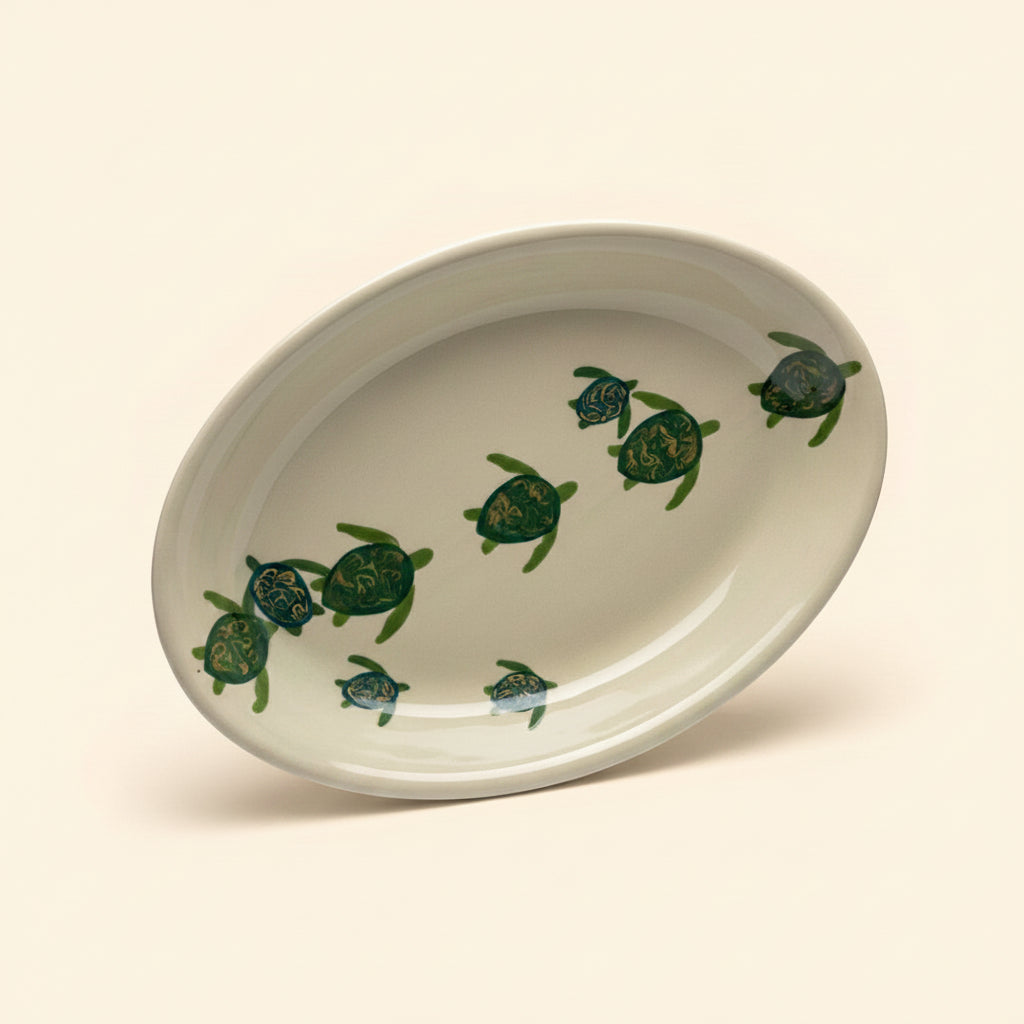 An oval-shaped ceramic platter with a green and beige turtle pattern