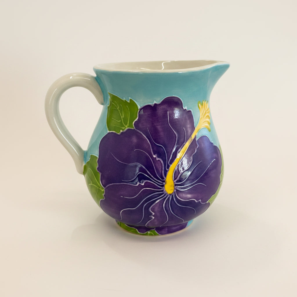 Creamer with purple floral design on a light gray background