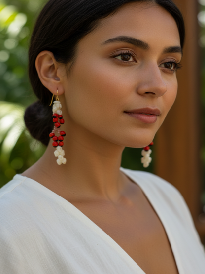 Pair of earrings with red, black, and white beads on a woman