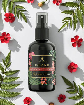 Black spray bottle with a decorative label on a white background with red flowers and green leaves.