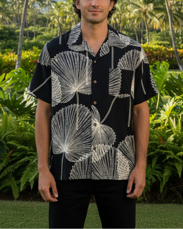 Black shirt with white floral pattern on a man with greenery behind