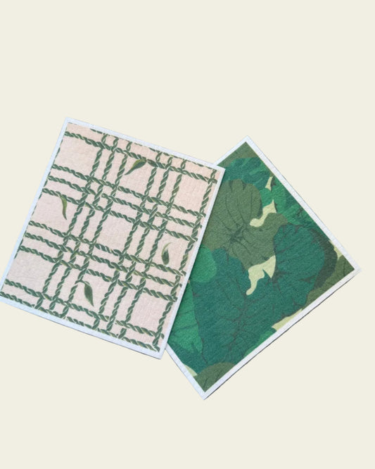 Two green and beige patterned cards on a textured surface