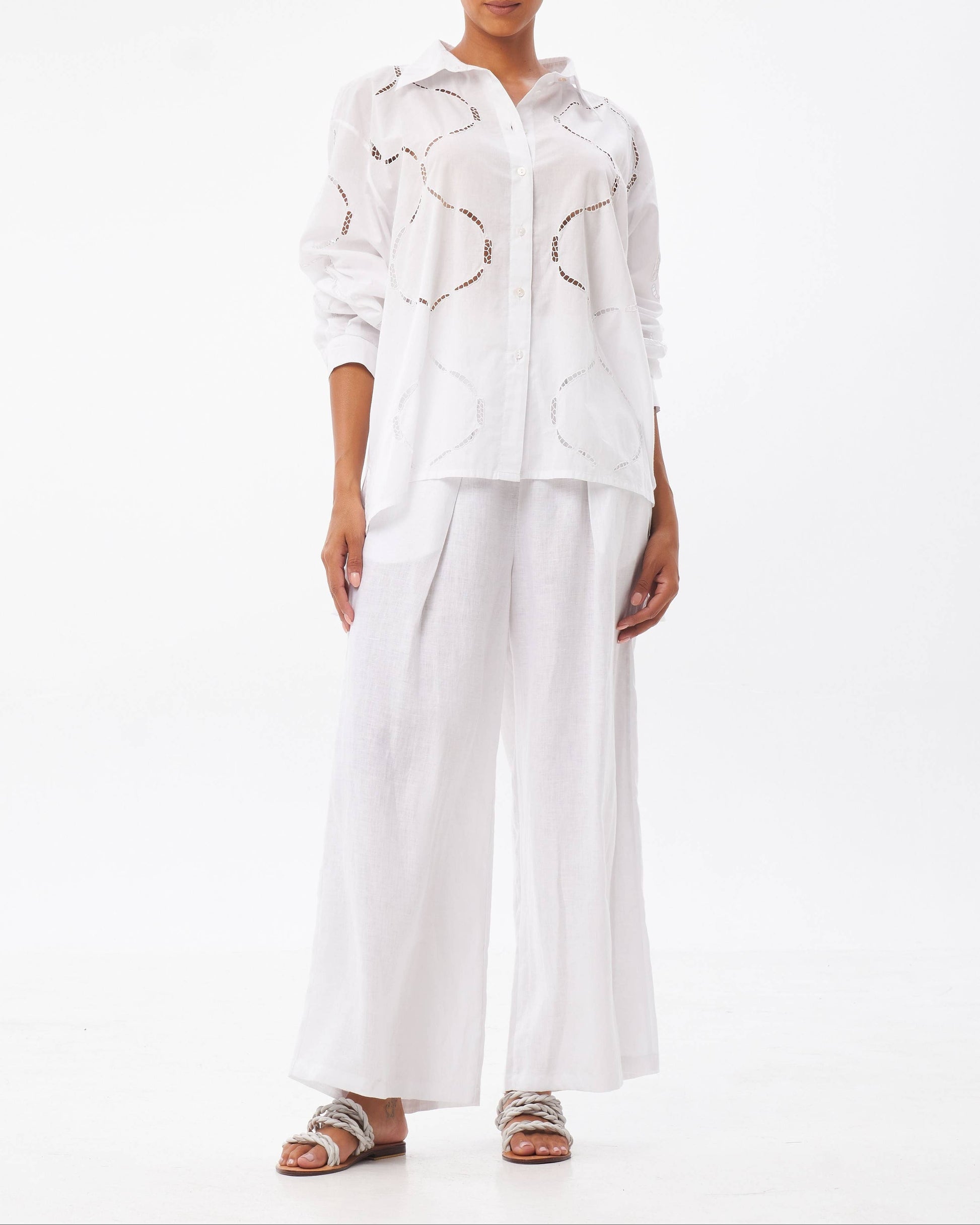 Woman wearing a white outfit with abstract patterns on a white background