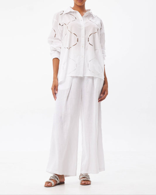 Woman wearing a white outfit with abstract patterns on a white background