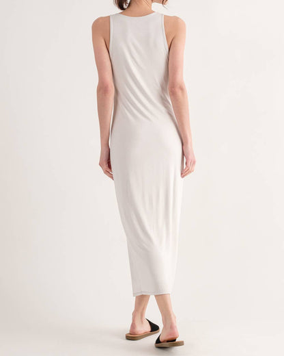 Woman wearing a white sleeveless dress on a plain background